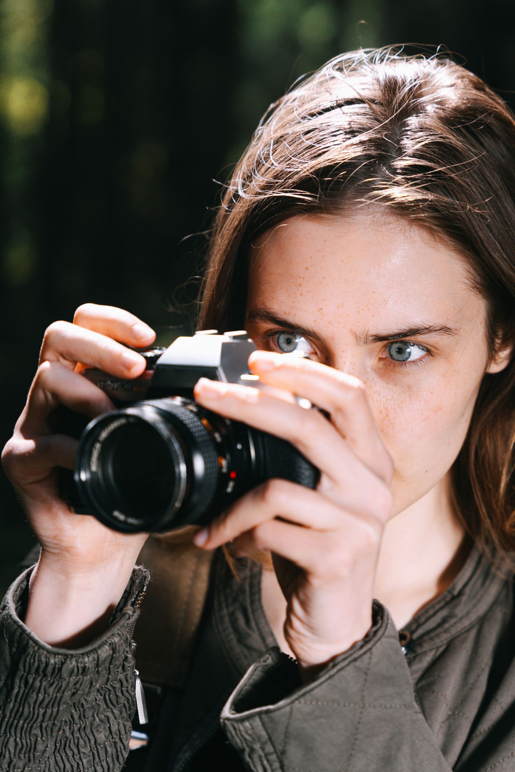Mara Voss standing outdoors with a camera